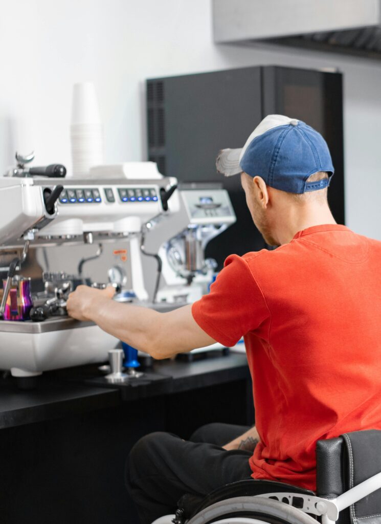 pexels-photo-7698022-7698022 Man in a wheelchair making coffee at a cafe, demonstrating inclusivity